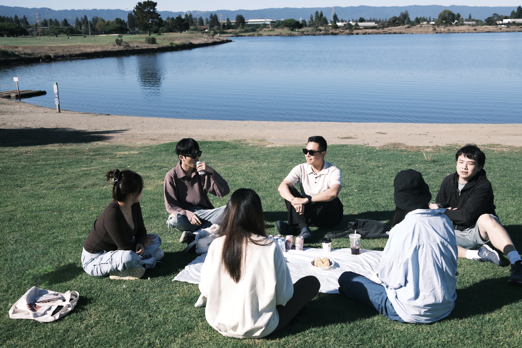Participants sitting in a circle by the water during AIC's first gathering.