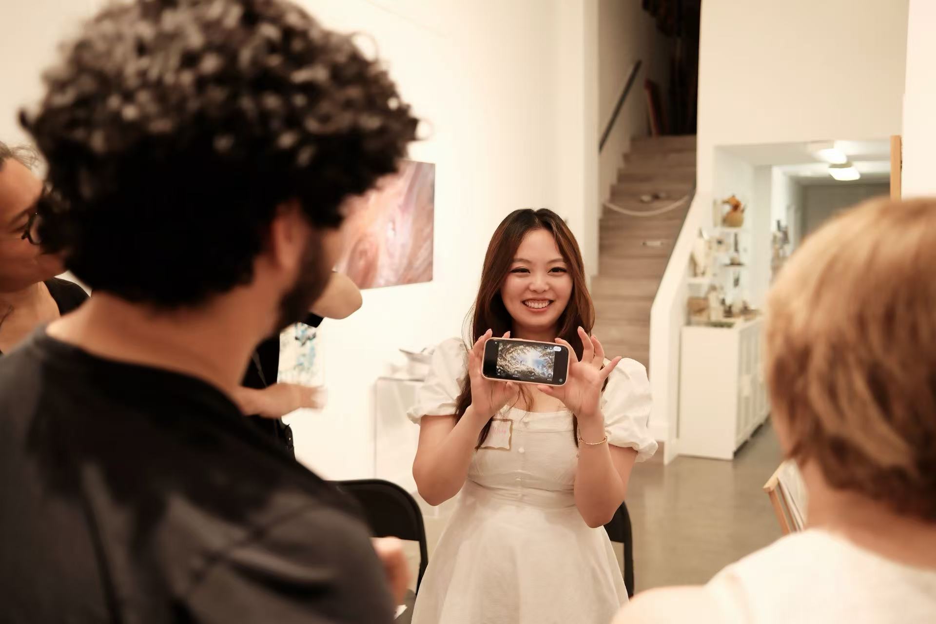 A participant showing an AI-created world on her phone during the fifth AIC gathering.